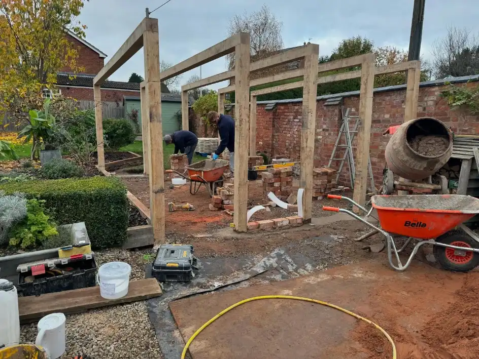 ATB Landscapes team building brick piers for an oak pergola in a garden